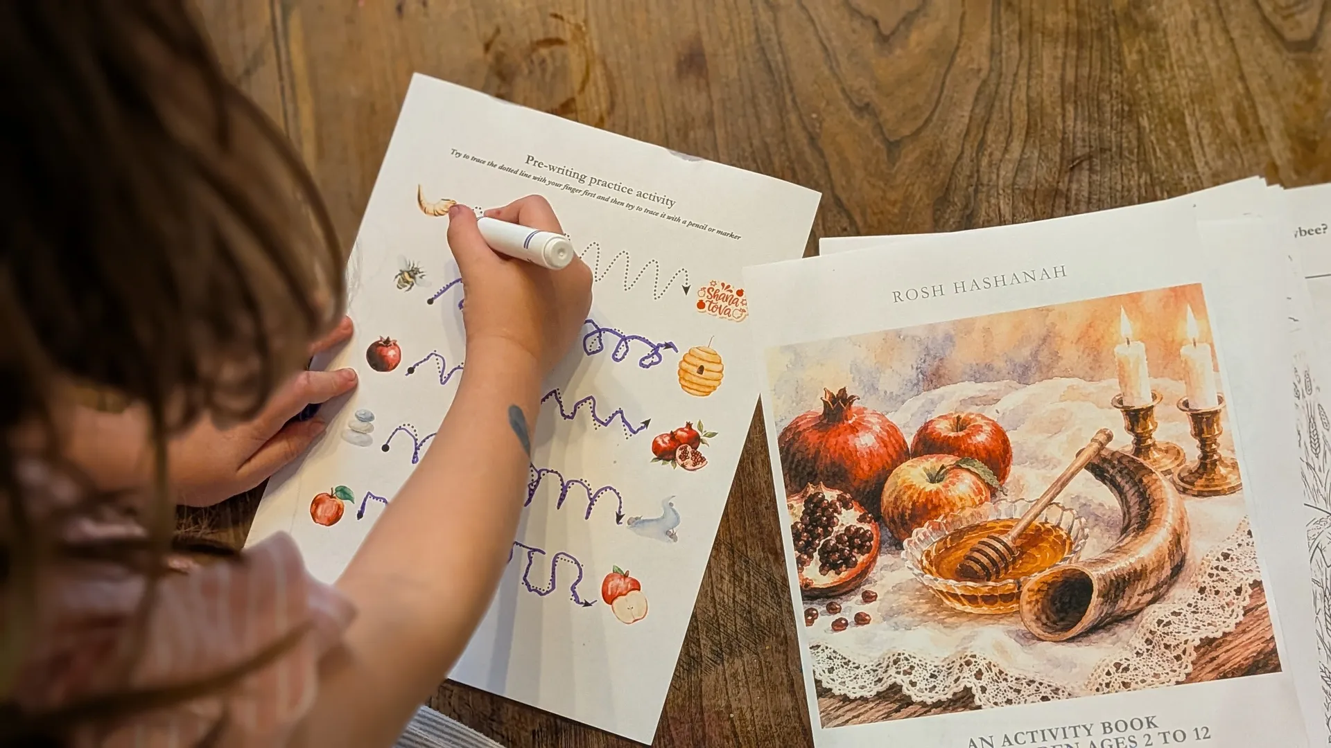 Children working on Feast of Trumpets activity pages at a family table