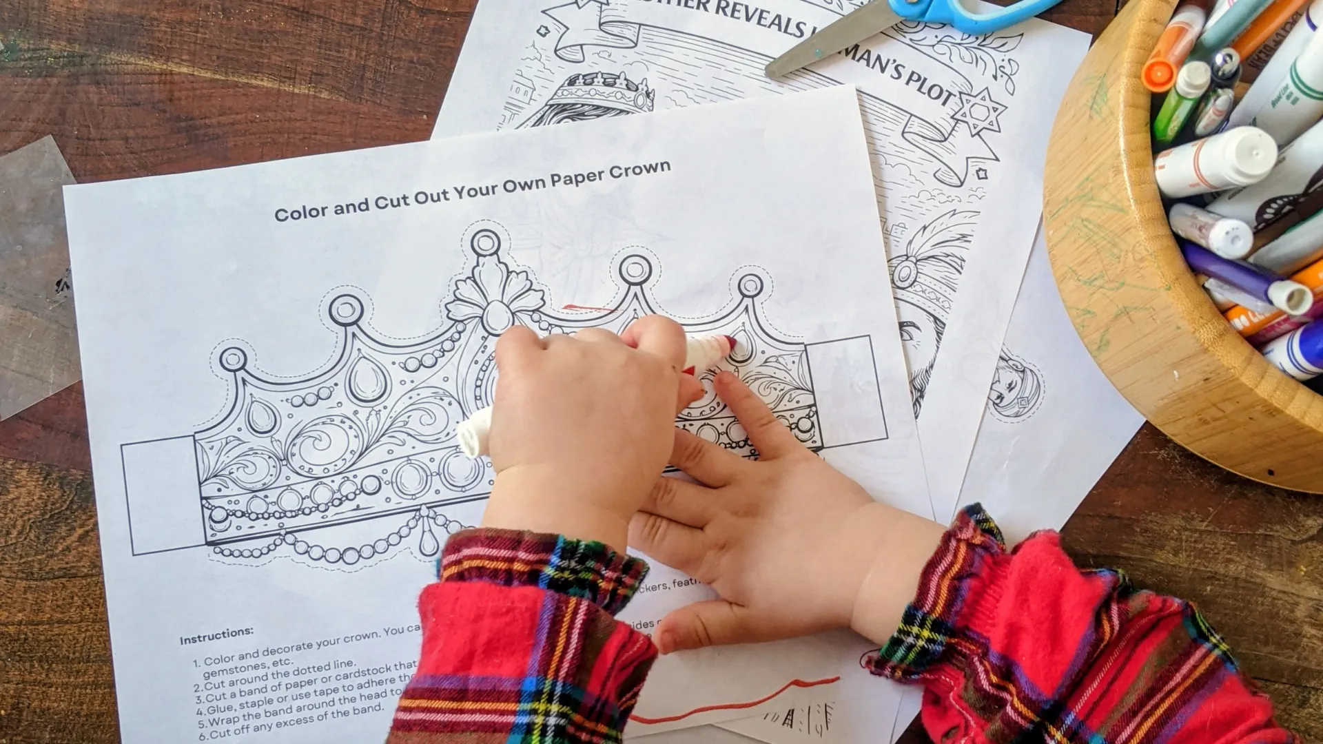 Little hands coloring the paper crown activity page