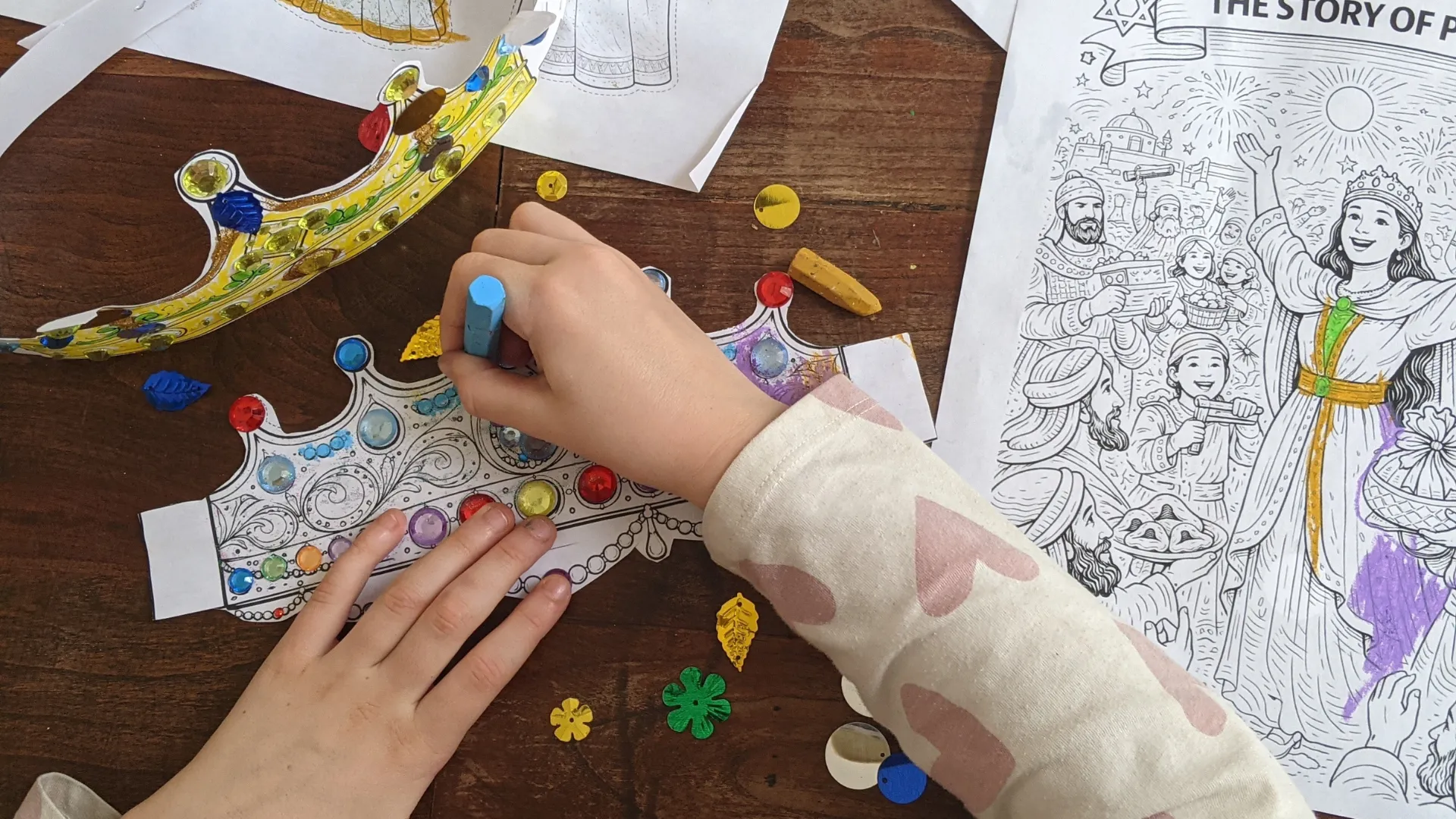 Child decorating a cut-out paper crown with stickers and markers